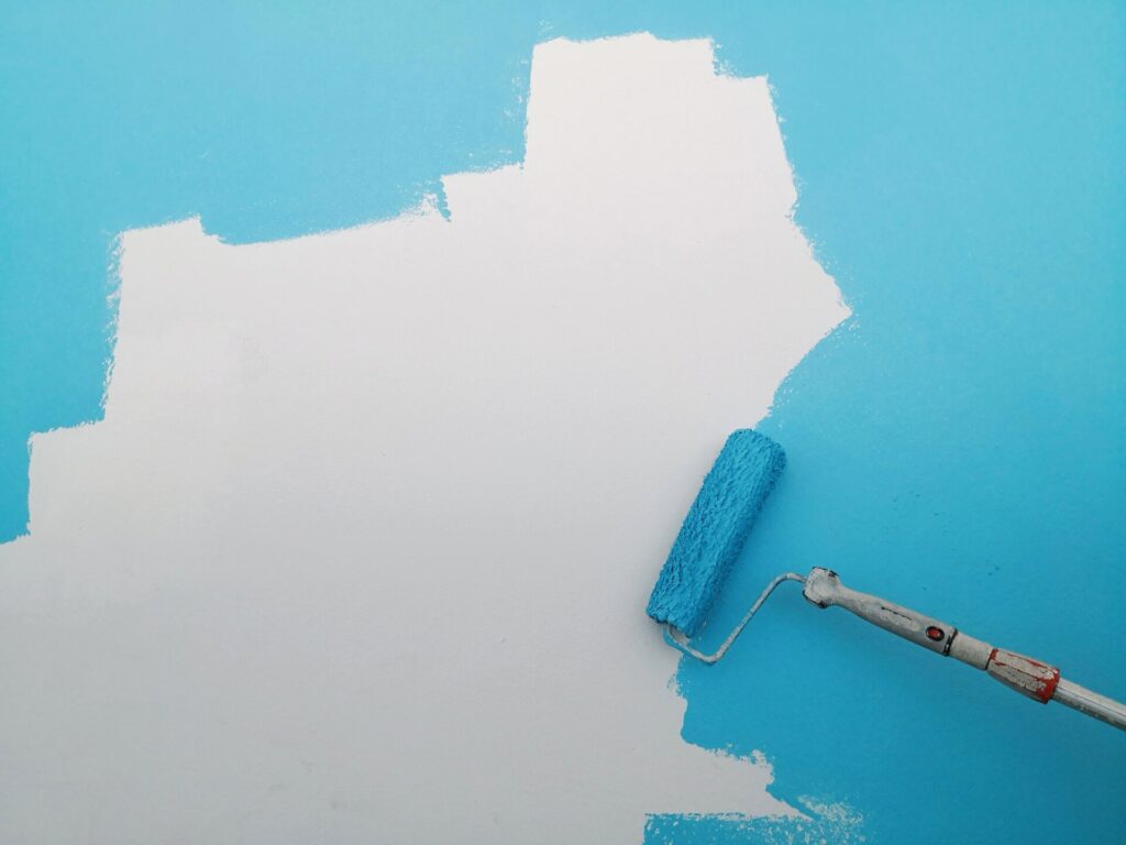Wand wird mit Malerrolle hellblau gestrichen