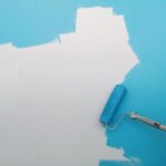 Wand wird mit Malerrolle hellblau gestrichen